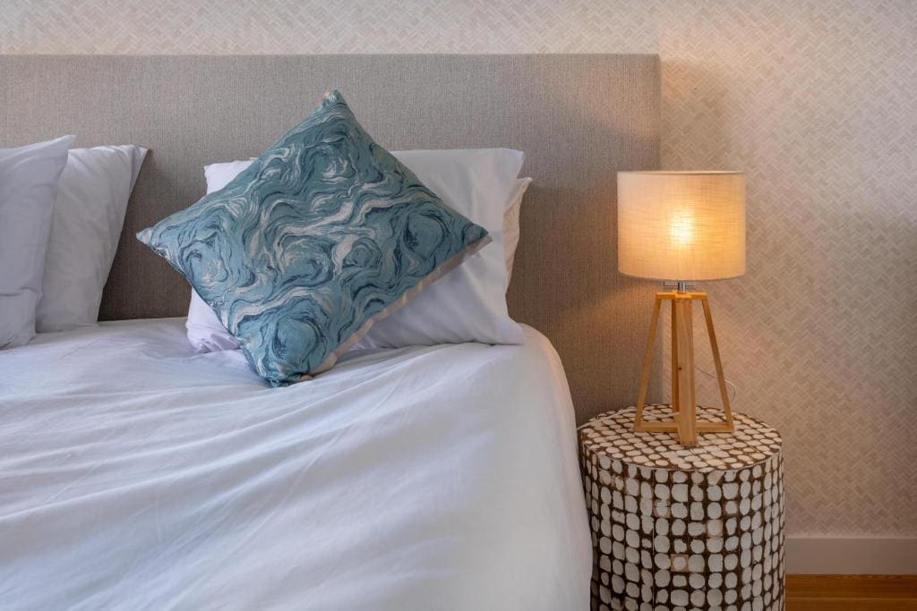 Pargo B bedroom at Bayline, Armação de Pêra: bed with patterned cushion and tripod bedside lamp