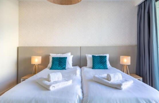 Pargo B bedroom at Bayline, Armação de Pêra: two single beds with teal cushions and bedside lamps