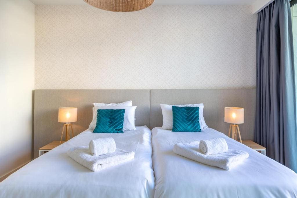 Pargo B bedroom at Bayline, Armação de Pêra: two single beds with teal cushions and bedside lamps