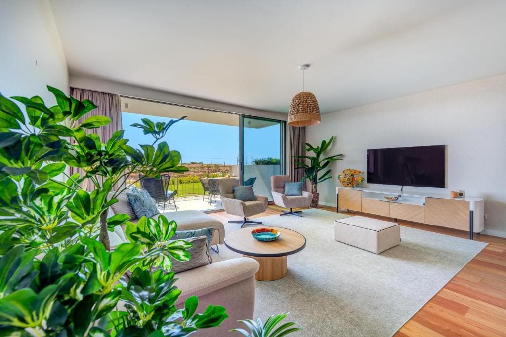Pargo B living room at Bayline, Armação de Pêra: sofa, armchairs, TV and glass doors to the terrace