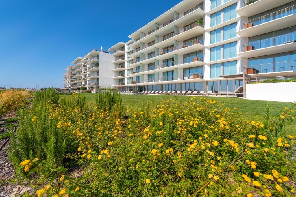 Bayline condominium in Armação de Pêra: apartment blocks behind flowering gardens and lawn