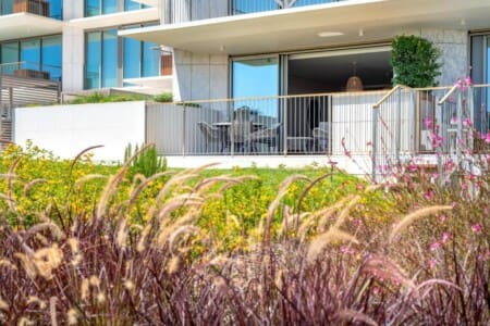 Pargo B at Bayline, Armação de Pêra: ground-floor terrace with outdoor dining set, seen from the gardens