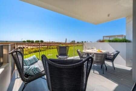 Pargo B terrace at Bayline, Armação de Pêra: rope armchairs and dining table overlooking the gardens