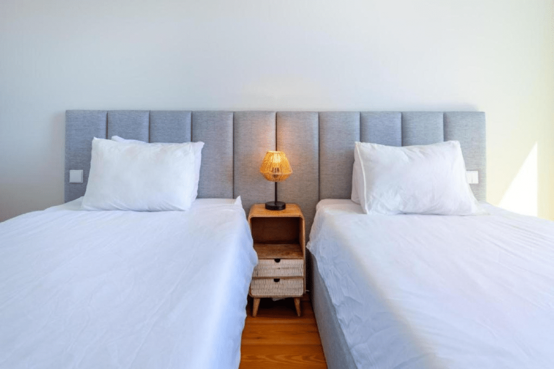 Nemo bedroom at Bayline, Armação de Pêra: two single beds with grey headboard and rattan lamp